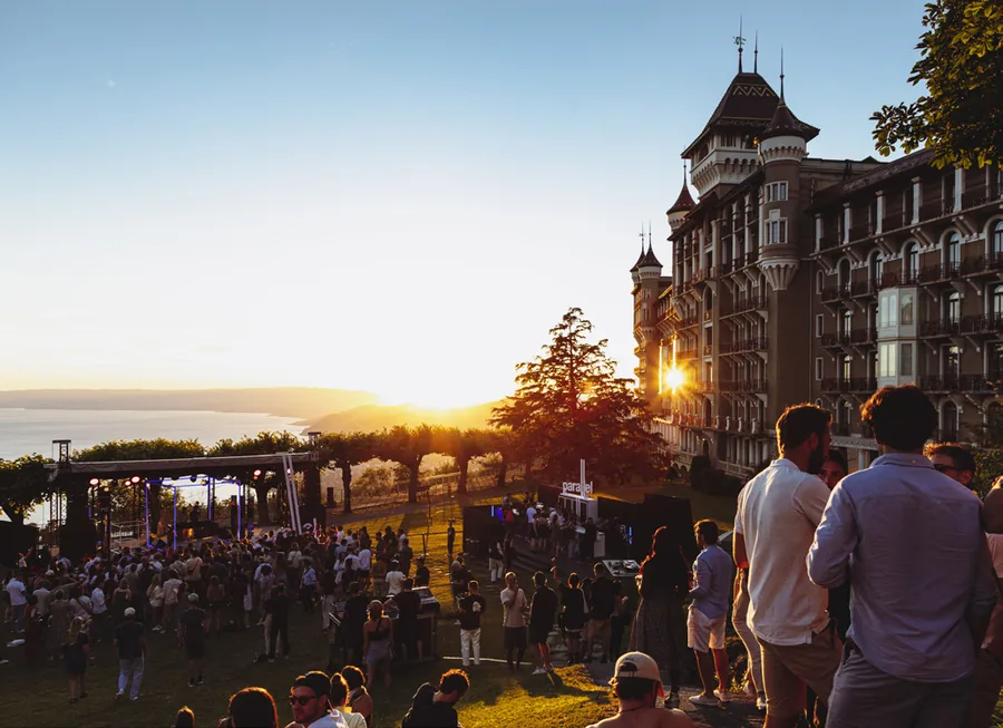 Montreux Jazz Festival: Festivalgäste auf einer Wiese über dem Genfersee bei Sonnenuntergang